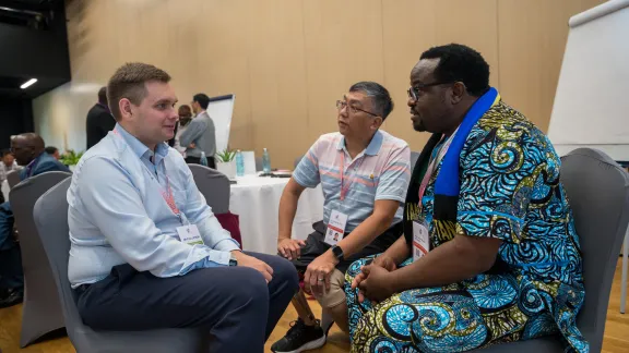 Men gather in small groups at their Pre-Assembly